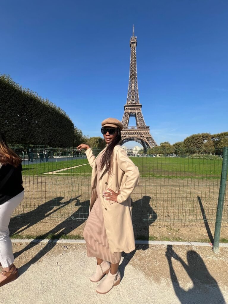 Clienta de Latin Trend con gabán claro frente a la Torre Eiffel en París